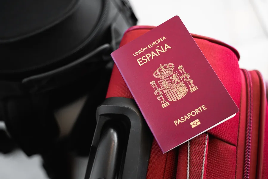 Pasaporte español sobre una maleta, como preparación de un viaje a Suiza